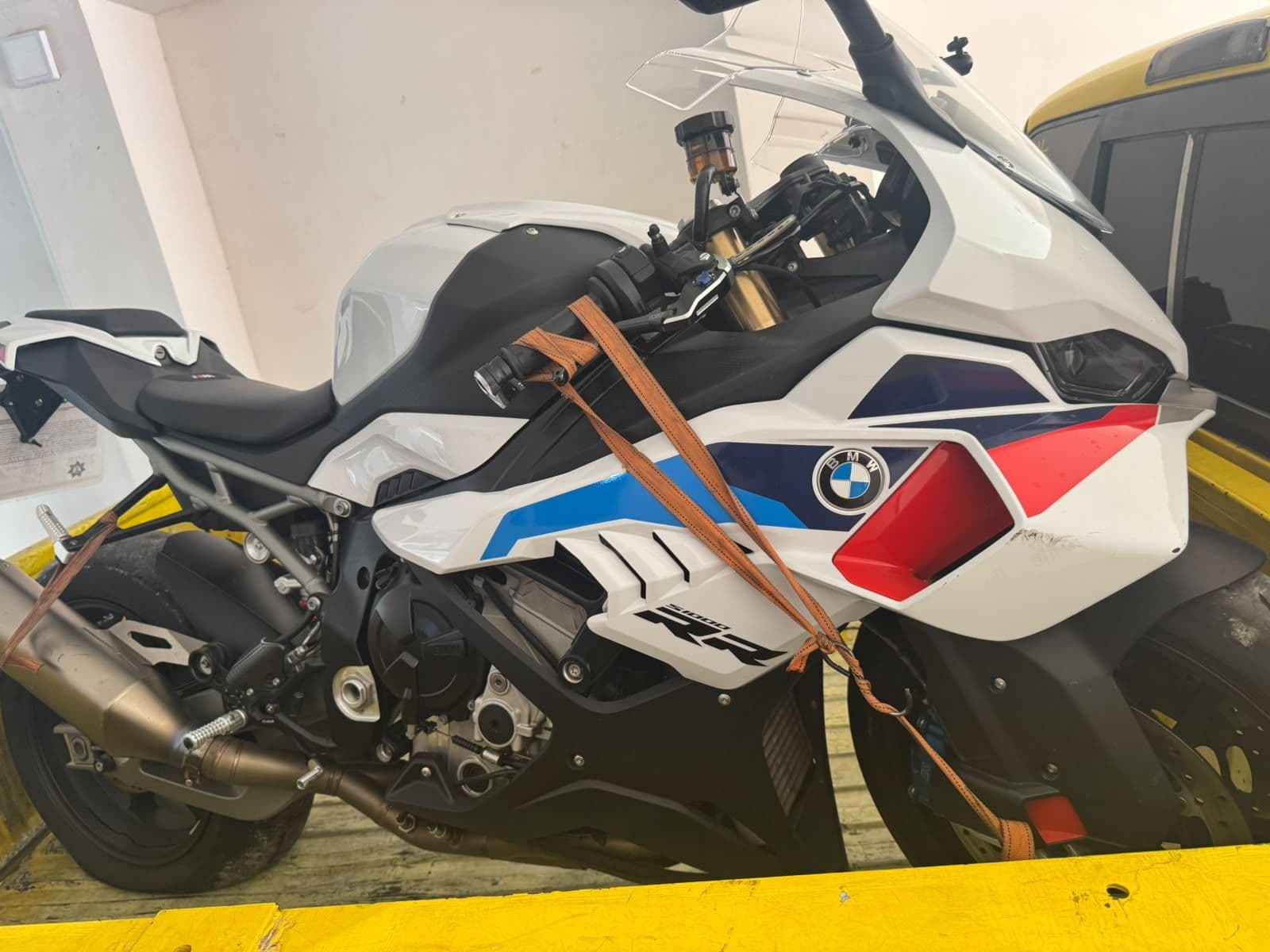 Motocicleta deportiva BMW sujeta con correas en la plataforma de la grúa