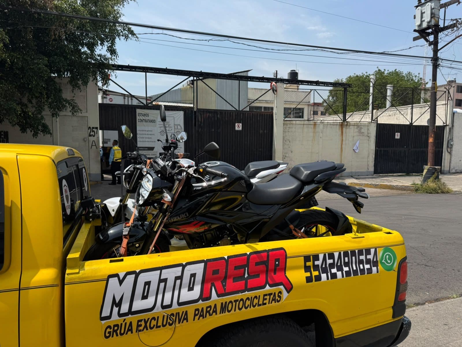 Motocicleta negra sobre la grúa de Moto-ResQ en la calle