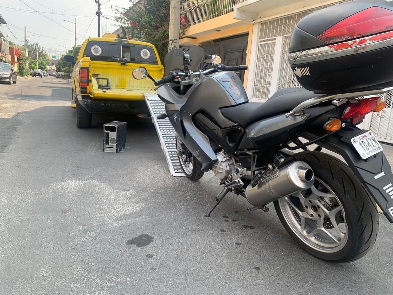 Motocicleta touring junto a la rampa, con la grúa de Moto-ResQ al fondo